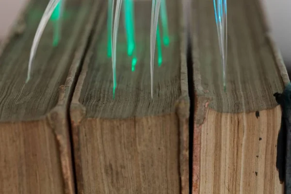 오래된 책과 연결된 빛나는 유리 섬유 케이블. — 스톡 사진