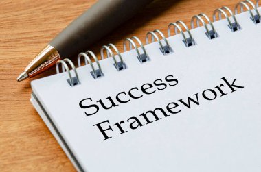 Başarı Çerçeve metnini odak noktasında beyaz sayfalarda gösteren not defterini kapat