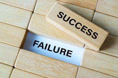Success and failure text written on wooden blocks showing contrast between achievement and setbacks