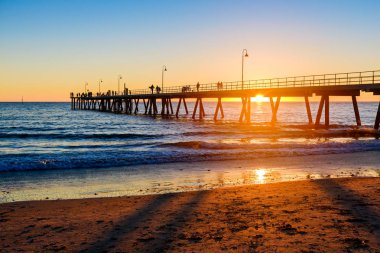 Gün batımında, Güney Avustralya Glenelg Beach iskelesi yürüyüş insanlar