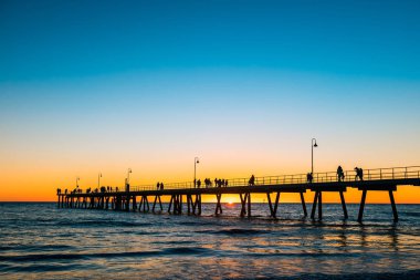 Gün batımında, Güney Avustralya Glenelg Beach iskelesi yürüyüş insanlar