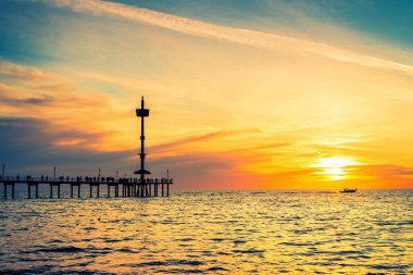 Gün batımında Brighton Jetty 'deki insanlar siluetleri