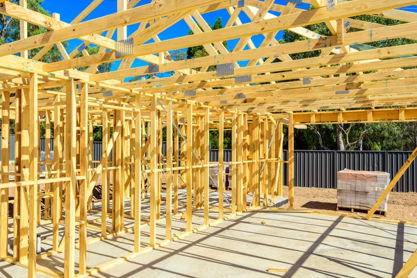 New Australian house construction site with timber frame installed and ready for bricklaying on bright summer day