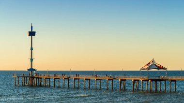 Günbatımında insanlarla Iconic Brighton Jetty, Güney Avustralya