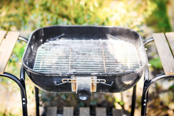 close up empty barbecue Grill in the backyard lawn at sunset