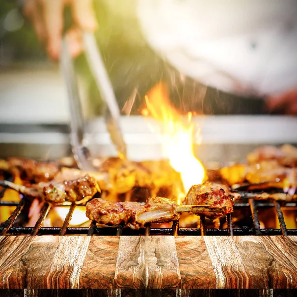 ホット炎でラムの肋骨を焼くシェフ 夜のバーベキュー料理 — ストック写真