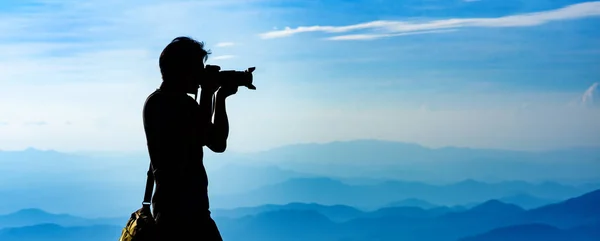 Silhueta de um fotógrafo mochileiro com montanhas camada baackground — Fotografia de Stock
