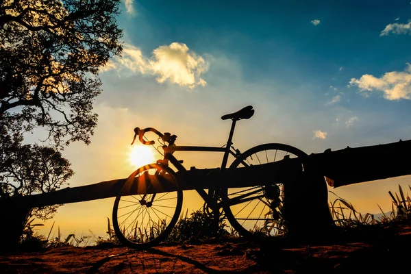 Fietser met een fiets silhouet op sunset sky background — Stockfoto