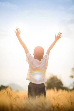 Yaz günbatımı gökyüzü açık buğday alanında rahatlatıcı mutlu kadın
