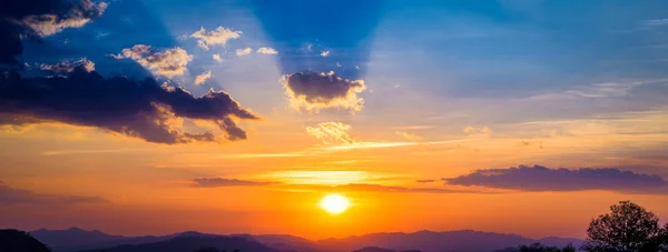 Paysage panoramique des montagnes au coucher du soleil avec nuages et rayons du soleil — Photo