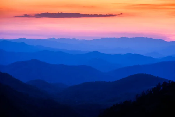 Dramatic sunset and sunrise sky and clouds over blue mountains — Stock Photo, Image