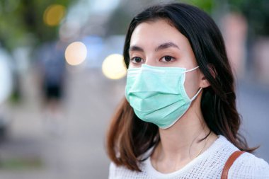 Genç, güzel Asyalı, güzel, Asyalı bir kadın nasıl tıbbi maske takılacağını gösteriyor ya da beyaz arka planda adım adım hijyen cerrahi maskesini nasıl takacağını gösteriyor.