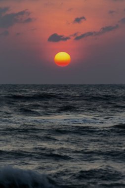 Büyük güneş kırmızı turuncu ve siyah bulutlar yağmur mevsimi başlamak.