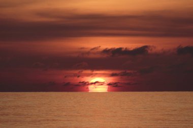 Büyük güneş kırmızı turuncu ve siyah bulutlar