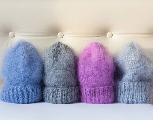 Four caps of different colors connected by hand from mohair — Stock Photo, Image