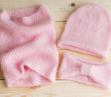 Kapaklar, boyunlu ve saç bantları bir dizi el ile gelen ahşap arka plan üzerinde pembe Angora örgü