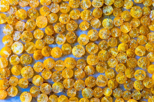 Sarı kiraz domates kurutma için hazırlanan beyaz parşömen üzerine baharatlar serpilir kesmek