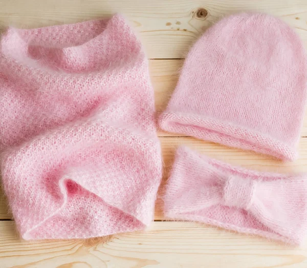 Kapaklar, boyunlu ve saç bantları bir dizi el ile gelen ahşap arka plan üzerinde pembe Angora örgü