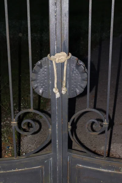 Siyah paslı kapıları ipe büyük bir düğüm ile kapalı.