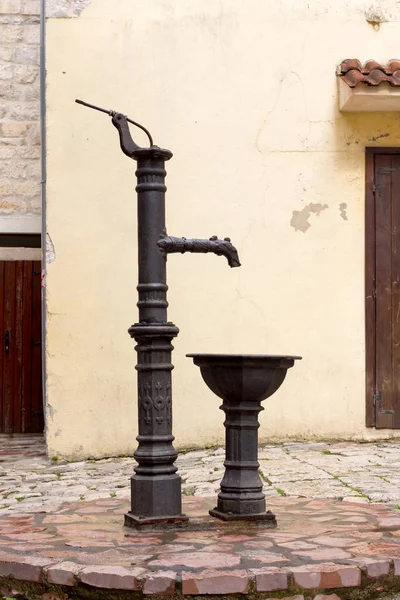 Medieval iron water pump and bowl in the old fortress of Kotor