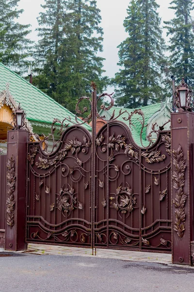 Wrought iron gate with lanterns painted in brown with gold color — ストック写真