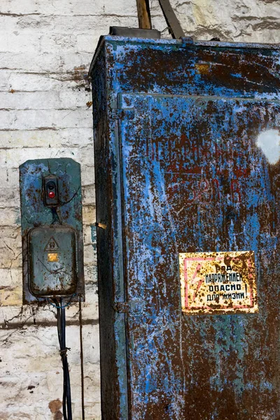 Dirty old electric switch 380 volts in the web and rust with Knoop start and stop, and an inscription in Russian "under stress, life-threatening" — Stock Photo, Image