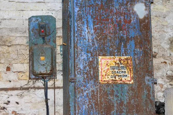 Dirty old electric switch 380 volts in the web and rust with Knoop start and stop, and an inscription in Russian "under stress, life-threatening" — Stock Photo, Image