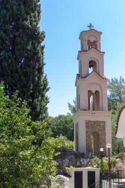 Ağacın yanındaki kilisenin çan kulesi.