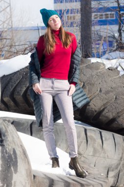 büyük lastikler üzerinde güneşte zümrüt örme şapka kız