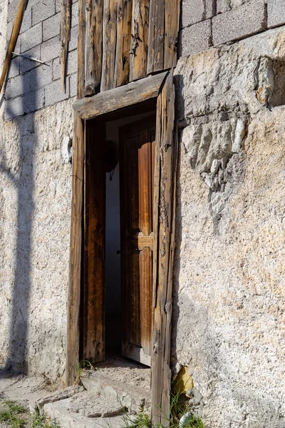 Stare drewniane drzwi w kamiennej ścianie — Zdjęcie stockowe