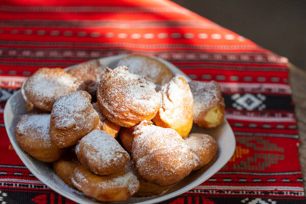romanian mini doughnuts on a plate on red traditional cloth