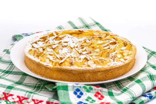 Beyaz arka planda beyaz tabakta lezzetli elmalı tart.