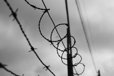 Gökyüzüne barbwire arkasında. Siyah ve beyaz.