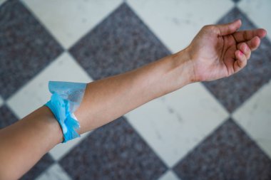 Kan bağışı sonra kadın kol mavi tül bandaj.