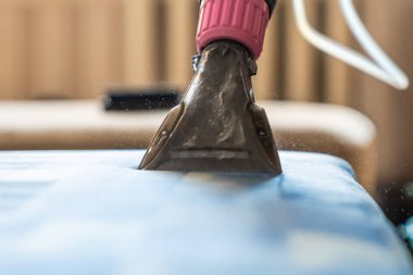 Kapitone kanepe profesyonel ayıklama yöntemi ile temizlik kimyasal closeup. Adam meme tutuyor.