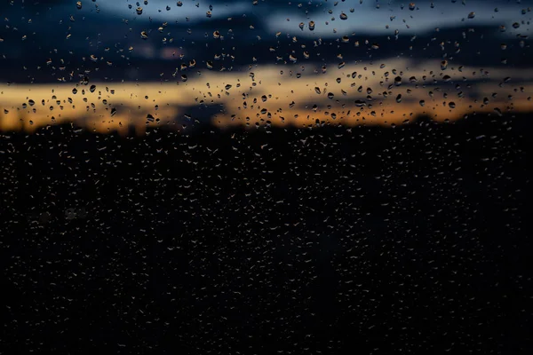 Nahaufnahme von Regentropfen am Fenster am Abend — Stockfoto