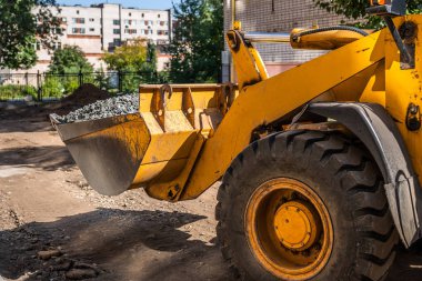 çakıl inşaat sahasında tarafından yüklü kova ile sarı yükleyici