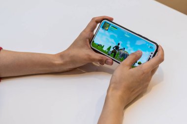 Elvan, Estonya - 15 Kasım 2018: bilgisayar oyunu oynamak online Fortnite oyun ile iphone ekranında, tutan kız