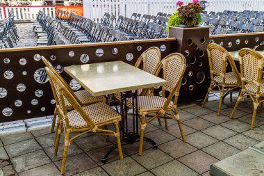 Beyaz, eski, tahta sandalyeli açık hava kafe masası.