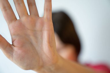 Genç kadın yüzünü elleriyle gizliyor, kısıtlama hareketi, mahremiyet, anonimlik konsepti