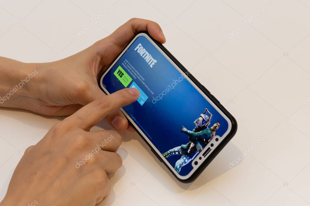 Elva, Estonia November 15, 2018 girl holding iphone with online Fortnite game Epic games, pressing no button.