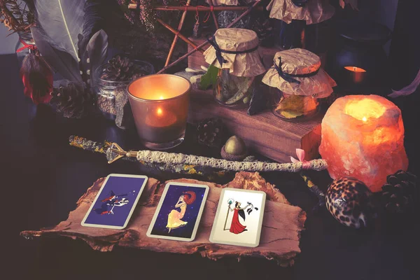 3 Tarot kartı sihirli eşyalarla birlikte siyah bir masaya yayılmış. Soğuk renklere bürünmüş — Stok fotoğraf