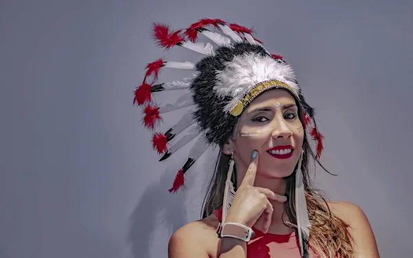 Portrait of a latin model with a feathered headdress with lights and shadows accentuated on her face