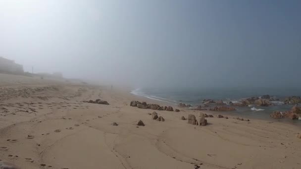 大西洋的景色。葡萄牙波沃亚德瓦尔齐姆空旷的海滩在雾蒙蒙的秋天，海浪在岸边冲击，远处有雾. — 图库视频影像