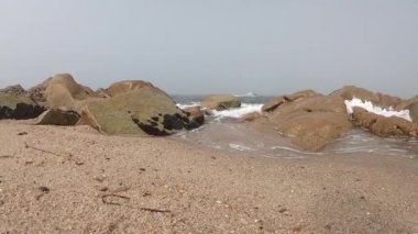 Atlantik Okyanusu manzarası. Povoa de Varzim Boş plaj, Portekiz sisli sonbahar gününde dalgalar aşağıda kıyıya çökmesini ve mesafe sis ile. Kıyıda taşlara vuran su.
