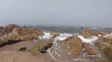 Atlantik Okyanusu manzarası. Povoa de Varzim Boş plaj, Portekiz sisli sonbahar gününde dalgalar aşağıda kıyıya çökmesini ve mesafe sis ile. Kıyıda taşlara vuran su.