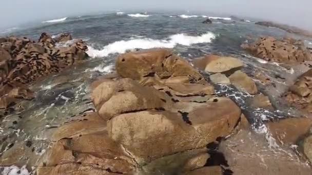 Vista para o Oceano Atlântico. Praia vazia em Povoa de Varzim, Portugal, no dia nebuloso do Outono, com ondas a despenharem-se na costa por baixo e nevoeiro à distância. Água batendo contra pedras na costa . — Vídeo de Stock