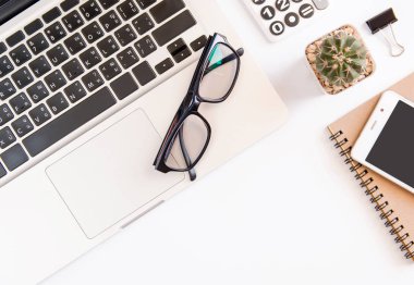 Beyaz ofis resepsiyon masası, dizüstü bilgisayar, smartphone siyah ekran, kalem, hesap makinesi, gözlük ile çalışma alanı office, Top kopya alanı görünümüyle