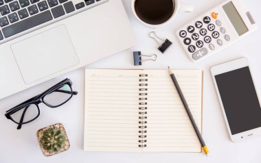Beyaz ofis resepsiyon masası, dizüstü bilgisayar, smartphone siyah ekran, kahve fincanı, kalem, hesap makinesi, gözlük ile çalışma alanı office, Top kopya alanı görünümüyle