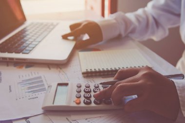 Masanın üzerinde evde mali verileri çözümleme ve dokunmatik laptop dokunmatik yüzey üzerinde mali hesap makinesi kullanarak adam ele 